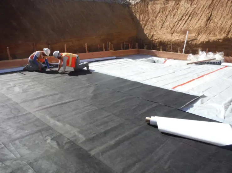 Workers install crawl space encapsulation to seal and protect.