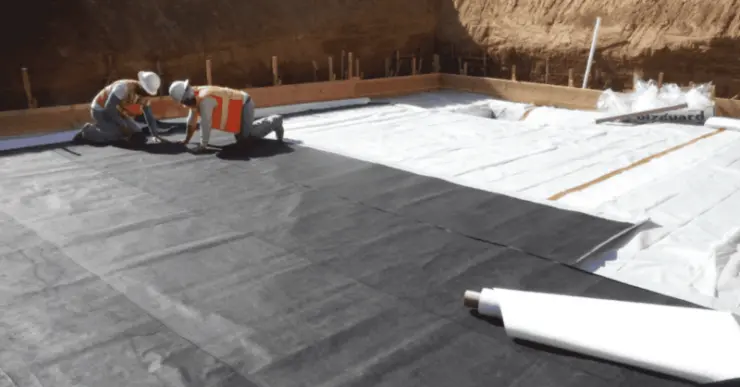 Workers lay a protective barrier before construction begins.