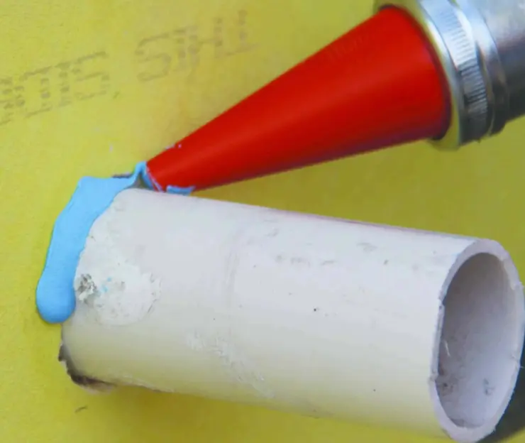 Applying sealant around a pipe to help with sealing basement walls against water intrusion.