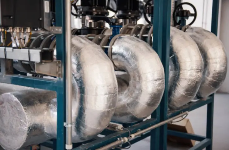 Insulated steam lines wrapped in metallic cladding for heat retention.