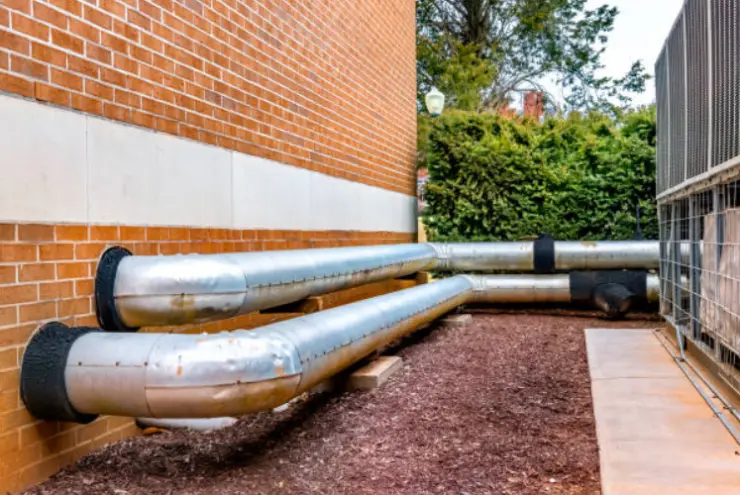 Outdoor HVAC line set insulation along a brick building.